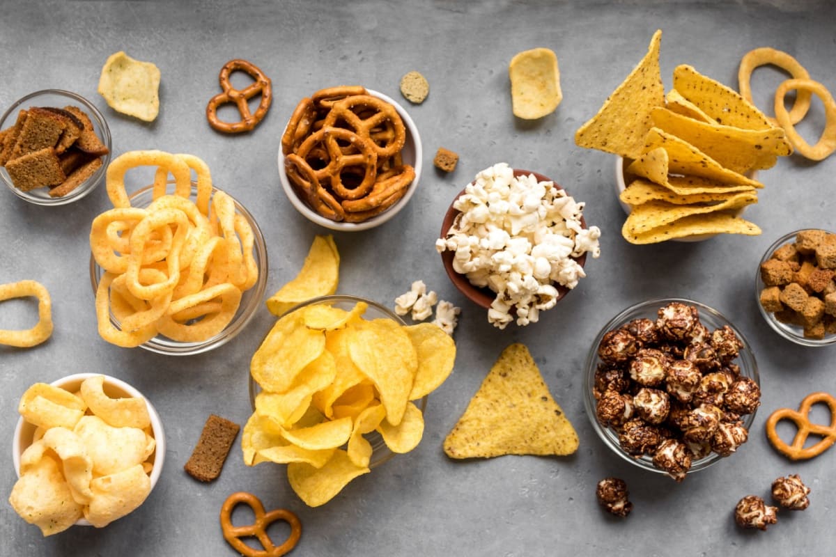 various-snacks-in-glass-bowls-displayed-on-a-grey-background