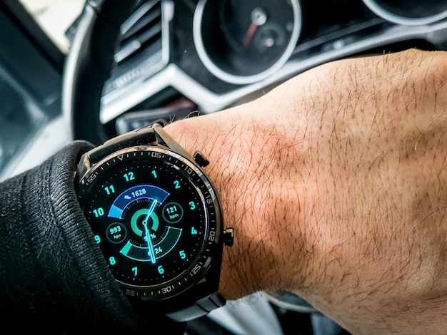 Free photo modern black watch on a wrist of a man sitting in a car