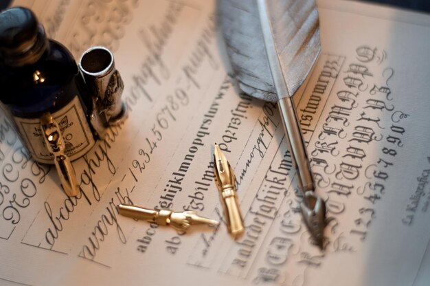 Macro shot of a quill set and an ink bottle on a piece of paper with calligraphy on it